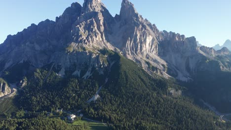 Aerial-tilt-up-showing-green-idyllic-valley-and-rocky-peak-of-Monte-Cristallo-in-Italy