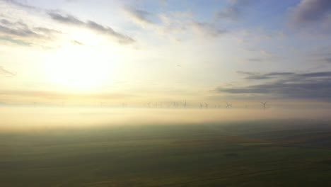 Distant-View-Of-Wind-Turbines-Rotating-In-Clouds-Against-Bright-Sunny-Sky
