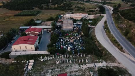 Aerial-descending-top-down-view-over-junkyard-in-the-countryside-with-old-cars-for-spare-parts