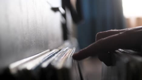 Male-hands-going-through-vinyl-records,-close-up-view
