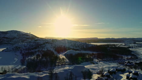 Ascending-drone-shot-of-sun-over-the-valley-in-winter-time