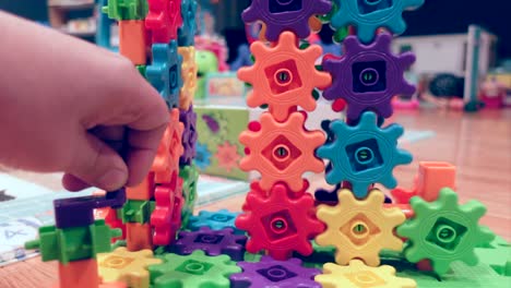 Hand-spinning-colorful-kids-gears,-close-up