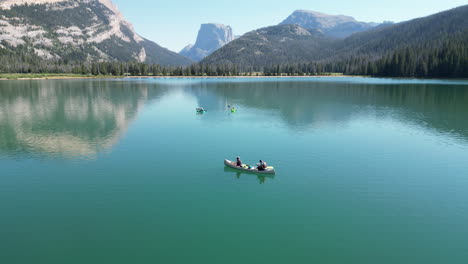 People-On-Canoe-Boats-Floating-On-Still-Water-Of-Green-River-Lakes-In-Wyoming