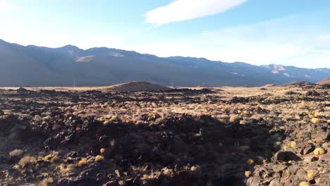 360-view-of-Fossil-Falls-volcanic-landscape-and-sun-light-beam-falling-on-ground-with-mountain-range-in-background