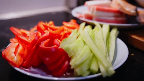 Zooming-Out-From-Tomato-And-Cucumber-Slices-Plate,-Ready-For-Sushi-Preparation
