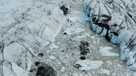Drone-tilt-up-reveals-glacial-lake-in-vast-Vatnajokull-glacier,-Iceland