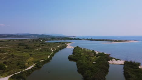 Descending-aerial-view-over-river-estuary-and-coastline--Strymonas-river-delta,-Greece