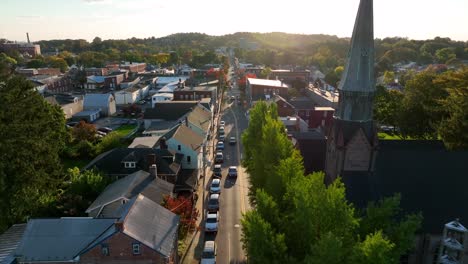 Aerial-pullback-reveals-church-steeple-and-old-homes-along-quiet-street-in-USA