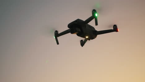 Close-up-aerial-of-drone-flying-in-mid-air-during-golden-hour
