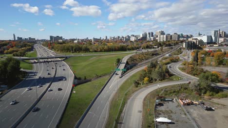 Traffic-Going-Along-The-Trans-Canada-Highway-With-Ottawa-City-Skyline-In-The-Distance
