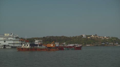 A-static-shot-of-a-Crane-barge-and-pontoon-anchored-in-the-Mandovi-River-on-a-beautiful-sunny-day,-Panjim,-India