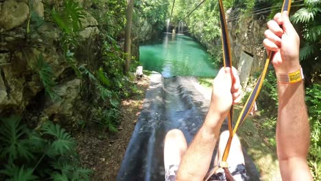 POV-zip-line-passing-a-waterfall-with-a-splash-landing-in-tropical-environment