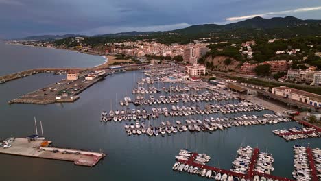 Luftaufnahme-Des-Jachthafens-Von-Arenas-De-Mar-Mit-Aufgedeckter-Bevölkerung-Im-Hintergrund