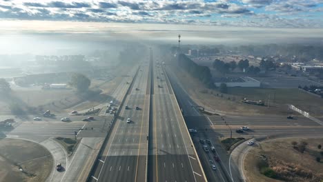Aerial-above-interstate-highway-covered-in-forest-fire-smoke,-smog-and-fog