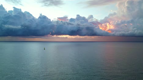 Un-Barco-Solitario-Navegó-Por-El-Mar-Con-Una-Nube-Roja-Sobre-él