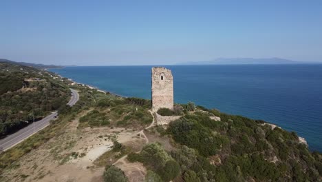 Aerial-circle-over-ruins-of-ancient-byzantine-Apollonia-Tower-by-coastline,-Greece