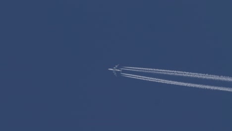 Four-engine-jet-aircraft-flies-across-a-blue-sky-leaving-a-track-bright-white-contrails-behind