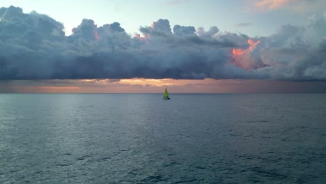Ein-Einsamer-Katamaran,-Der-Bei-Sonnenaufgang-Mit-Einer-Sturmformation-über-Den-Ozean-Fährt