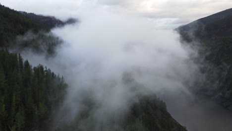 Fliegen-In-Richtung-Wolken-Mit-Blick-über-Einen-See,-Berge-Und-Einen-Wald