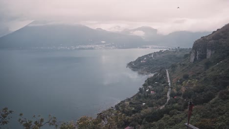 Majestic-foggy-view-of-lake-Atitlan-and-mountains-in-Guatemala,-handheld-view-from-above