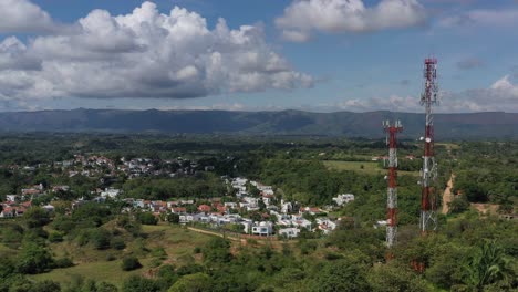 drone-aerial-shot-of-mobile-technology-antennas-with-a-village-behind-the-antennas