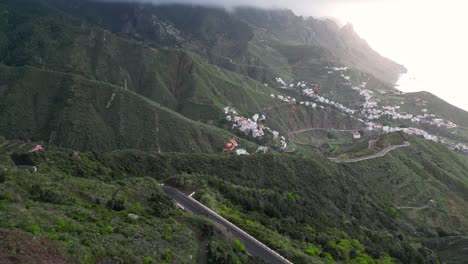 Beautiful-aerial-view-of-several-towns-between-the-green-mountains-of-Tenerife-with-the-sea-in-the-background-at-sunset