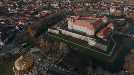 Panorama-aerial-drone-flight-over-a-orthodox-church-and-the-castle-Cetatea-Făgărașulu-in-Făgăraș-in-România---Fagaras-in-Romania-is-a-touristic-city-in-the-historical-region-of-Transylvania