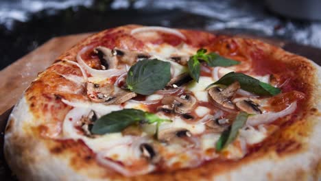 Nahaufnahme-Einer-Hausgemachten-Sauerteigpizza-Mit-Basilikum-Salsa-Pilzen,-Zwiebeln-Und-Mozarrella-Käse