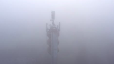 Mobile-network-antennas-on-a-water-tower,-transmitting-in-bad-weather,-aerial-view