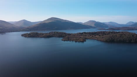 Pan-round-Loch-Lomond-water-and-view-over-islands-to-Ben-Lomond-mountain-on-a-sunny-day