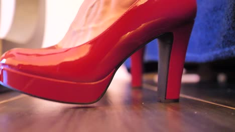 a-woman-in-shimmering-red-high-heeled-stilettos-is-nervous
