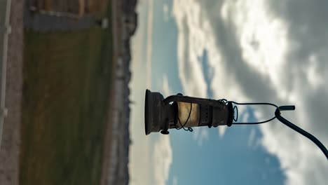 A-vintage-lantern-with-a-cloudscape-in-the-background---parallax-motion-time-lapse-in-vertical-orientation