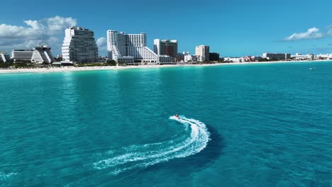 Aerial-view-following-a-water-scooter-in-front-of-the-Hotel-zone,-in-sunny-Cancun,-Mexico