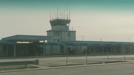 Retro-Flughafen-Mit-Einem-Flugzeug,-Das-Im-Hintergrund-Den-Himmel-überquert