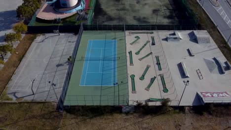 Aerial-top-down-over-outdoor-sport-facilities-with-courts-and-skate-park