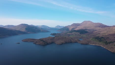 High-angle-approach-of-Ben-Lomond-and-Scottish-Mountains-over-Loch-Lomond-island-on-a-sunny-day