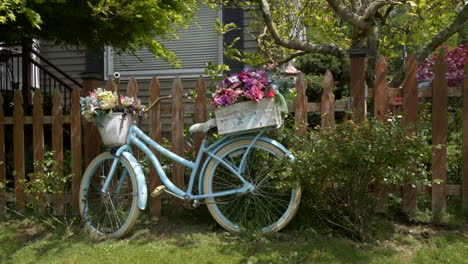 Bicycle-Planter-with-flowers-along-picket-fence-with-trees-and-shrubs