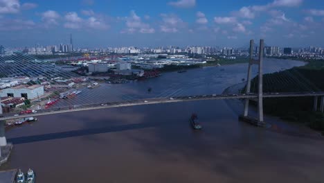 Luftaufnahme-Von-Phu-My-Bridge-über-Den-Saigon-River-Mit-Straßen--Und-Flusstransport-An-Einem-Sonnigen-Tag