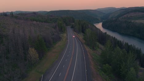 Drone-Shot-of-Emergency-Fire-Vehicle-Driving-on-Highway-next-to-River-during-sunset