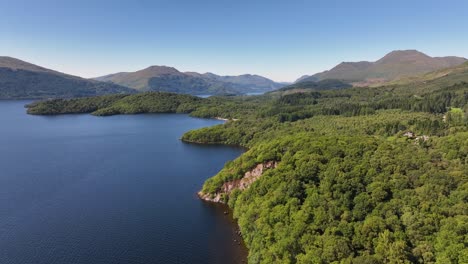 Flying-Along-the-Side-of-Loch-Lomond-Shore-to-lift-up-and-Reveal-Ben-Lomond-and-Mountains-Short