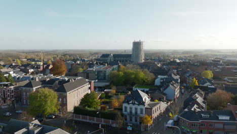 Scaffolding-Around-the-Clock-Tower-of-the-Basilica-of-Our-Lady-in-Tongeren,-Aerial-Forward