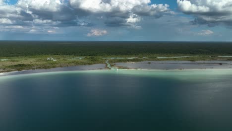 Aerial-view-towards-a-catamaran-in-shallow,-turquoise-waters-of-lake-Bacalar-Lagoon,-in-sunny-Mexico