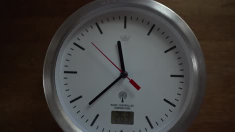 White-clock-ticking-on-wooden-desk