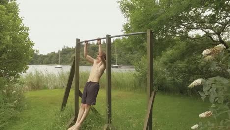 Athletic-young-man-reps-pullups-on-outdoor-home-gym-Realtime