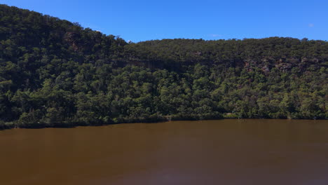 drone-shot-of-Large-Brown-River-with-hills-trees-and-bushes-Hawkesbury-New-South-Wales