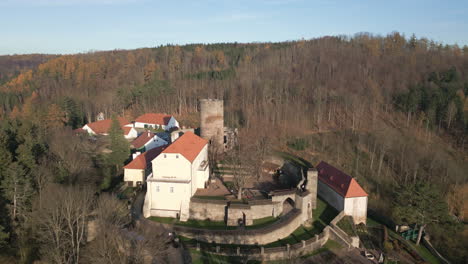 Aerial-shot-of-Svojanov-Castle,-situated-on-a-hill-in-the-middle-of-forests