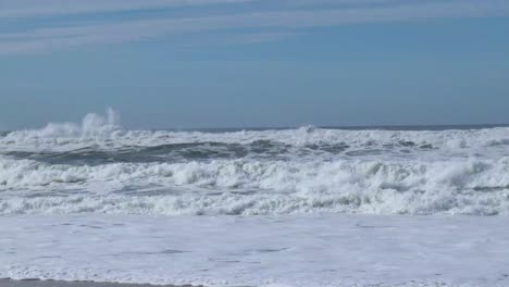 Weiße,-Mit-Einer-Kappe-Bedeckte-Wellen,-Die-An-Der-Küste-Am-Strand-In-Nazare,-Portugal,-Zusammenbrechen