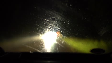 Driving-a-car-at-nighttime-while-raining-with-windscreen-wiper