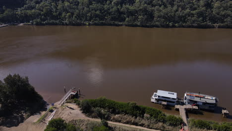 drone-shot-of-Large-Brown-River-with-hills-trees-and-bushes-river-boat-Hawkesbury-New-South-Wales