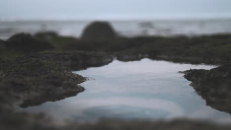 Rockpool-at-the-seaside-reflects-an-overcast-cloudy-sky